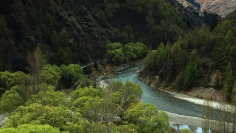 Tracking drone shot of blue alpine river running through New Zealand forest Stock Footage 89866504