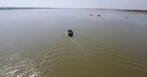  tracking drone shot of a dredging boat proceeding down river to pump sand Stock Footage 101636241