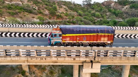 Tracking drone shot of heavy transport lorry driving on a concrete bridge. Видео 337761610