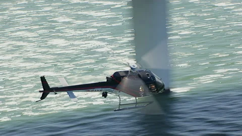 Tracking with fast Astar helicopter flying low near bridge on water Stock Footage 136200880