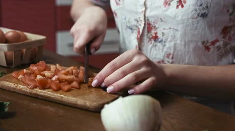 Tracking footage of female hands rake up tomato slices into a big blue salad Stock Footage 61258617
