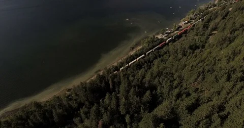 Tracking forward shot following a train along beach front revealing valley Video stock 93419622