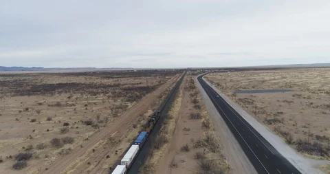 Tracking freight train alongside road through the desert drone aerial 4K Stock Footage 111315161