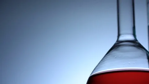 Tracking low angle shot of chemical glass flasks and test tube with colored Stock Footage 75941630