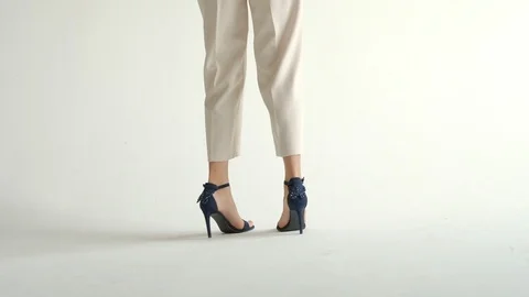 Tracking with low-section of silhouette of female legs in high heels shoes Stock Footage 108230127