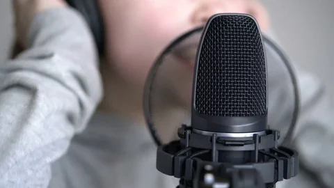 Tracking macro shot of microphone in music studio with singing cute little Video stock 75174491