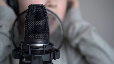 Tracking macro shot of microphone in music studio with singing cute little Stock Footage 75175044