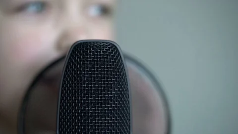 Tracking macro shot of microphone in music studio with singing cute little Video stock 75176614