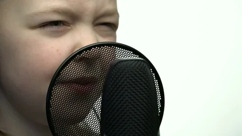 Tracking macro shot of microphone in music studio with singing cute little Video stock 75178382