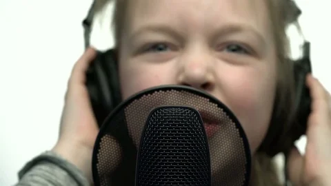 Tracking macro shot of microphone in music studio with singing cute little Stock Footage 75179123
