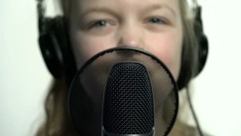 Tracking macro shot of microphone in music studio with singing cute little Stock Footage