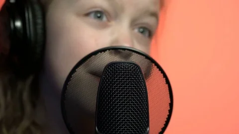 Tracking macro shot of microphone in music studio with singing cute little Stock Footage 75182472