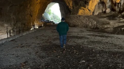 Tracking Man Walking Inside Zugarramurdi Cave 動画素材 323115831