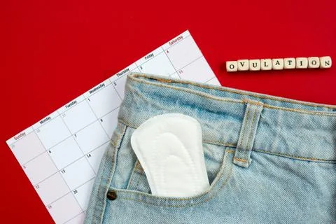 Tracking the menstrual cycle and ovulation. on a red background women's pads  Stock Photos
