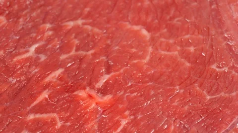 Tracking over flat marbled beef slice, low angle. Meat texture. Dolly shot. Stock Footage 121227079