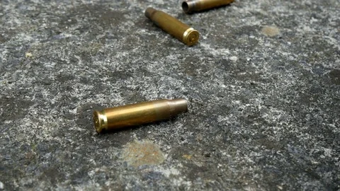 Tracking over spent bullets in street Stock Footage 77781785