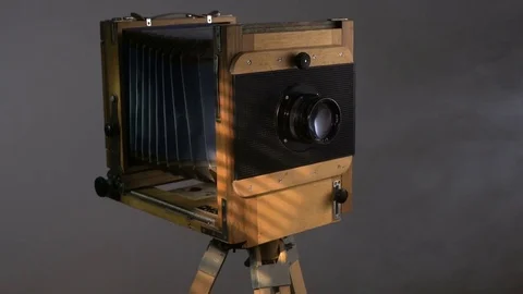 Tracking PAN mid shot of old vintage wooden photo camera lighting by sunlight Stock Footage 75888199