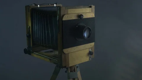 Tracking PAN mid shot of old vintage wooden photo camera lighting by sunlight Stock Footage 75888523