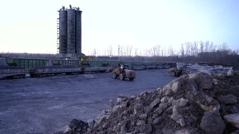 Tracking PAN of ore storage. Tiltdozers load ore into gondola cars Stock Footage 75283378