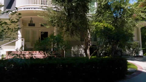 Tracking past a white house with round porch and trees Stock Footage 345711601