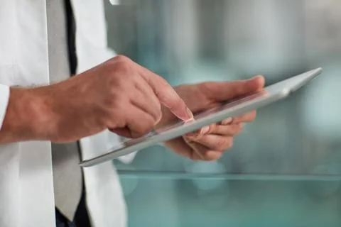 Tracking a patients progress. Closeup shot of an unrecognisable doctor using a Stock Photos