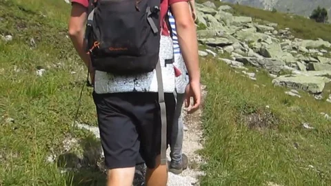 Tracking people with backpacks in the mountains Stock Footage 81137758