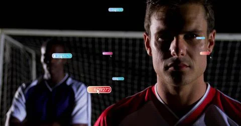 Tracking player wearing red-white jersey on night soccer field with net and data Stock Photos
