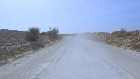 Tracking rear back pov shot driving fast on dirt road splashing dust in the air Stock Footage 111885336