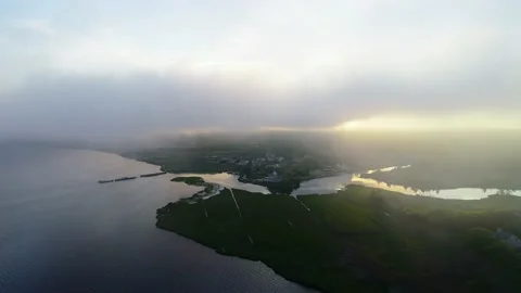 Tracking right on quaint town on ocean through heavey overcast Stock Footage 155463420