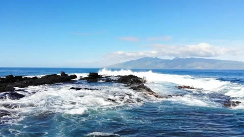 Tracking right on rocks and surf off the coast of Maui Stock Footage 155460159