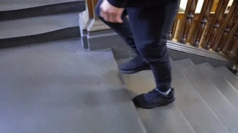 Tracking Shoes of Man Walking Up Staircase in Old Building Stock Footage 118963339