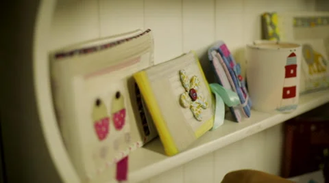 Tracking shot across shelf of stitched craft goods Stock Footage 44289625