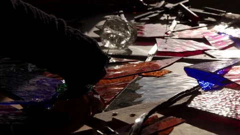 Tracking shot across a work bench with colored stained glass window Stock Footage 83444783