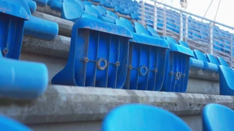 Tracking Shot Along Folded Blue Flip-Up Stadium Seats on Concrete Terraces 動画素材 346654165