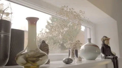 Tracking shot along letterbox window sill with vases and ornaments (1 of 2) Stock Footage 127269834