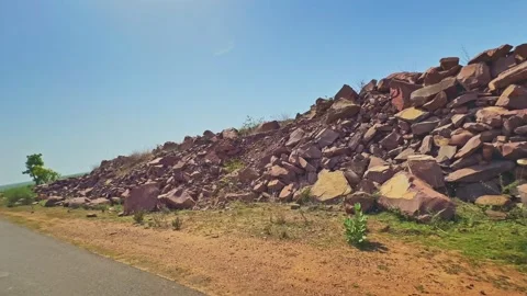 Tracking Shot Along Roadside Rockfall with Stacked Sandstone Boulders Under Stock Footage 340183529
