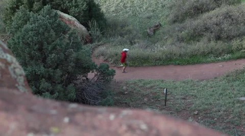Tracking shot along rocks of runner speeding along trail Video stock 51333044