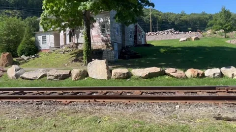 Tracking Shot Along Train Tracks Past Old House And Parked Trucks Stock Footage 344899493