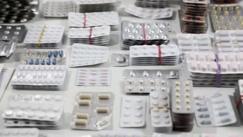 Tracking shot alongside desk full of medication blisters Stock Footage 286218649