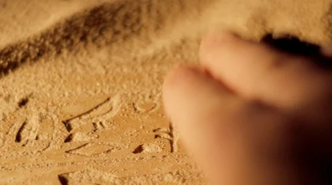 Tracking shot of archaeologist brushing sand from ancient Egyptian hieroglyphics Stock Footage