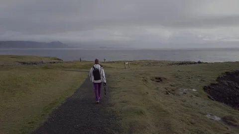 Tracking shot of backpacker walking to a cliff in Iceland. 動画素材 143830176