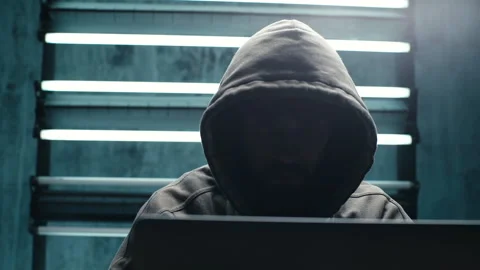 Tracking shot of bearded hacker man wearing sweatshirt with hood breaking Vídeos de archivo 145121657