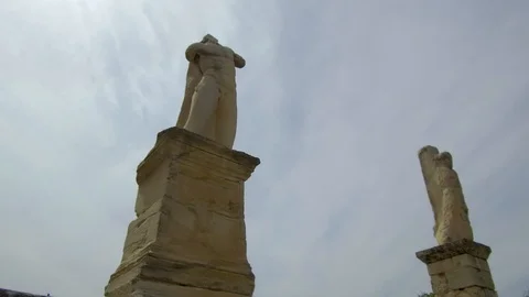 Tracking shot camera moves around ruins of remaining statues of The Roman Agora Video stock 92439383