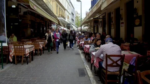 Tracking shot camera moves forward in street people sitting in restaurants Stock Footage 92440492