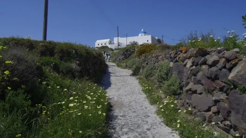 Tracking shot camera moves forward uphill in narrow pathway with stones on side Stock Footage 92441098