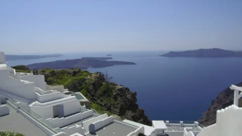 Tracking shot camera moves slowly around Santorini buildings with a pan to sea Stock Footage 92441049