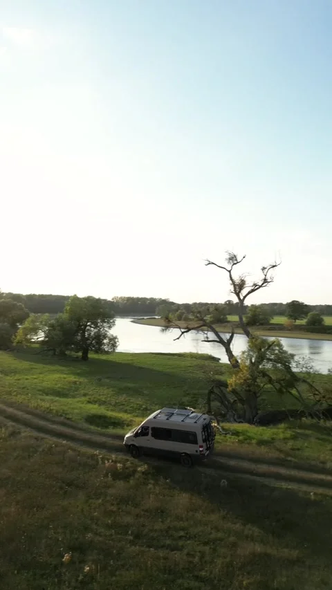 Tracking shot of a camper van driving in nature next to a river Video stock 226206444
