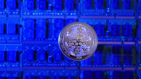 A tracking shot of Cardano ADA crypto currency coin hovering over a mining Stock Footage 160949934
