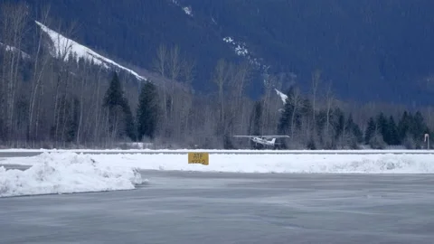 Tracking shot of Cessna 152 Taking off from Pemberton Airport during snowy Stock Footage 148062809