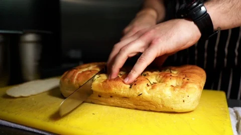 Tracking shot of chef cutting garlic bread Stock Footage 106810695